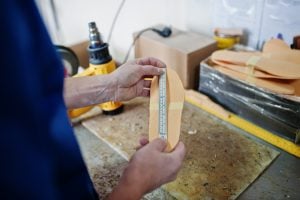 Prosthetist man making orthopedic insoles while working in labor